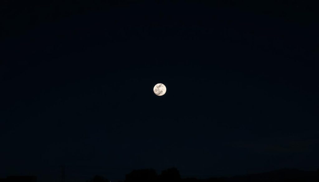 A night sky over the United States, with a prominent full moon in the center. The moon's surface is detailed, with craters and shadows visible. The sky is dark and clear, with a few wispy clouds. Soft moonlight illuminates the landscape below, creating a serene and contemplative atmosphere. In the foreground, silhouettes of trees or buildings may be visible, adding depth and scale to the scene. The overall composition should be balanced and visually appealing, conveying a sense of tranquility and the astrological significance of the moon's presence.